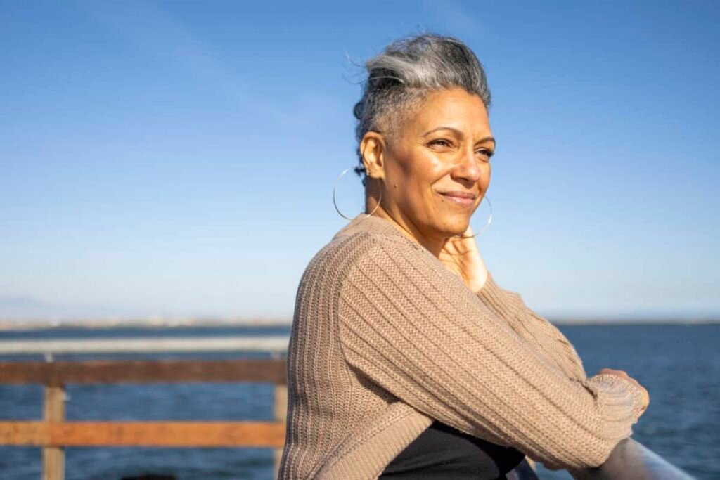 woman looks ahead of her over water
