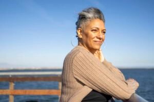 woman looks ahead of her over water