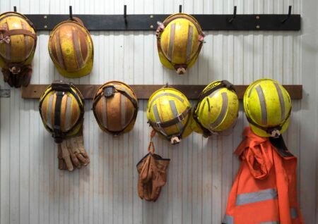 Canada Shed 68,000 Jobs in September: October 28 Rate Decision Now More Challenging Safety helmets and gloves hang from a rack on a mining site.