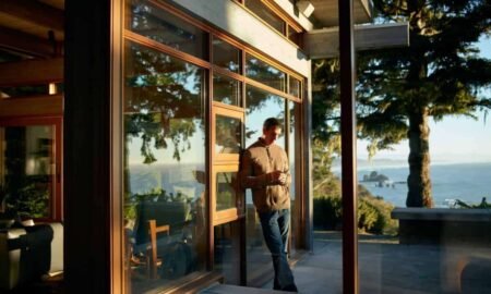 Is BCE Still a Good Investment? Here’s My Opinion. person on phone leaning against outside wall with scenic view at airbnb rental property
