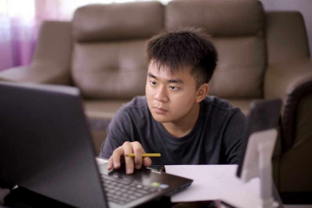 Starting Your First Investment Account in Canada: Essential Information Before You Hit “Apply” Young adult concentrates on laptop screen