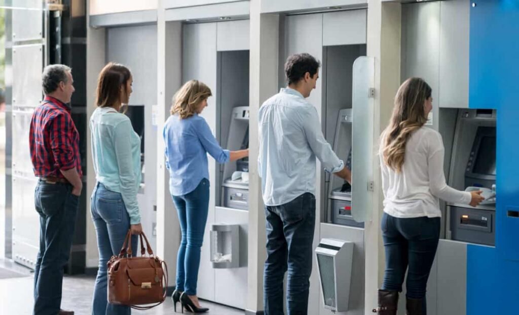 The Essential TFSA Withdrawal Guidelines for All Canadians Group of people in a line at an ATM waiting to make a cash withdrawal