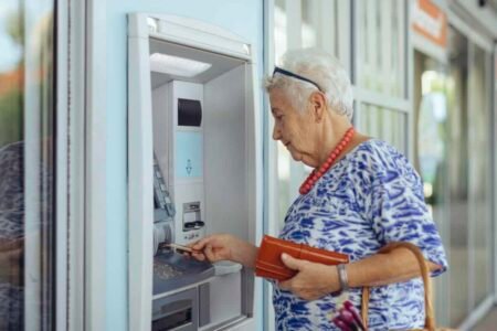 Your GIC Is Coming Due Amid Rising Rates: Consider Not Reinvesting Automatically customer uses bank ATM
